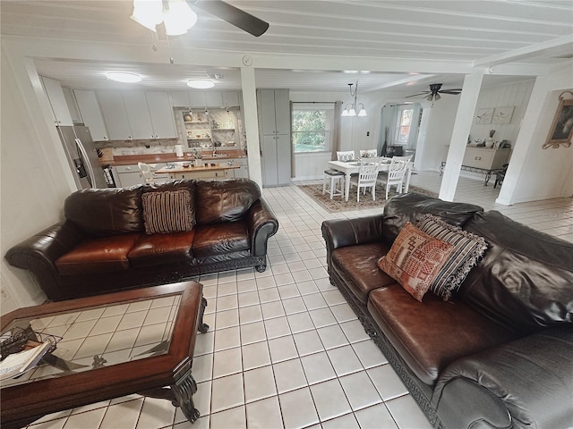 living room with ceiling fan with notable chandelier and light tile patterned flooring