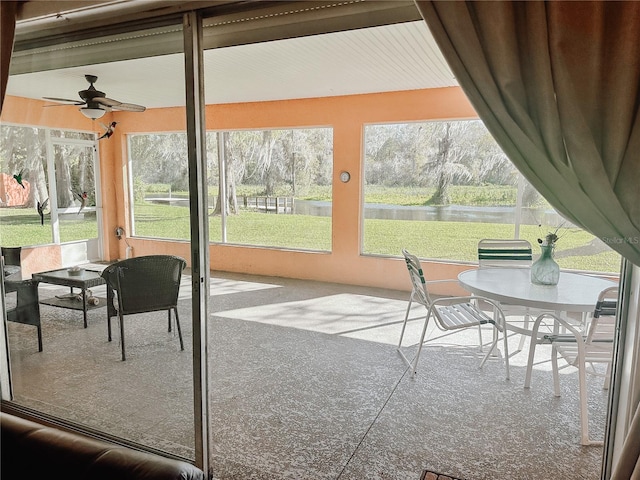 sunroom / solarium featuring plenty of natural light and ceiling fan