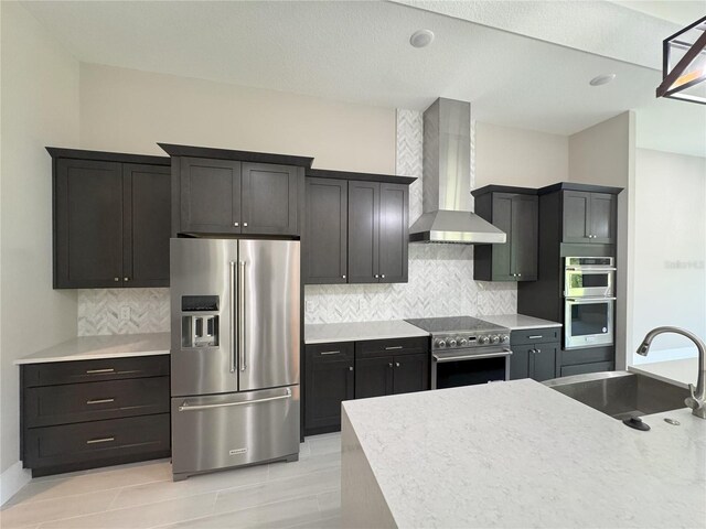 kitchen featuring backsplash, sink, wall chimney exhaust hood, and appliances with stainless steel finishes