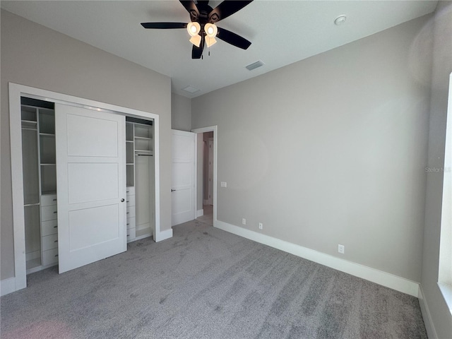 unfurnished bedroom with ceiling fan, light colored carpet, and a closet