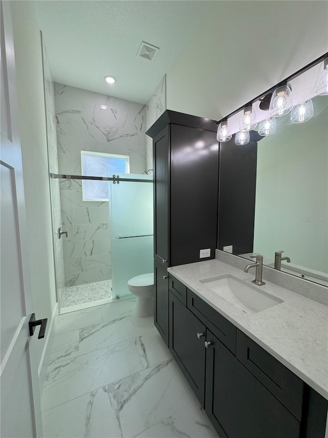 bathroom with vanity, toilet, and tiled shower