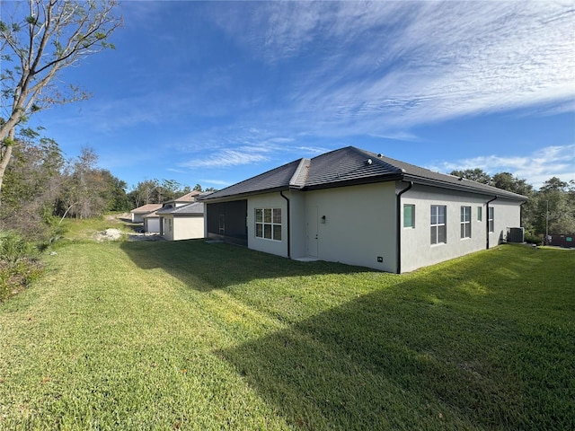 back of property featuring cooling unit and a yard