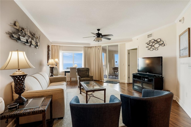 living room with dark hardwood / wood-style floors, ceiling fan, and crown molding