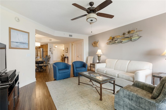 living room featuring dark hardwood / wood-style floors, ceiling fan, and crown molding