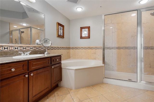 bathroom with tile patterned floors, vanity, shower with separate bathtub, and tile walls