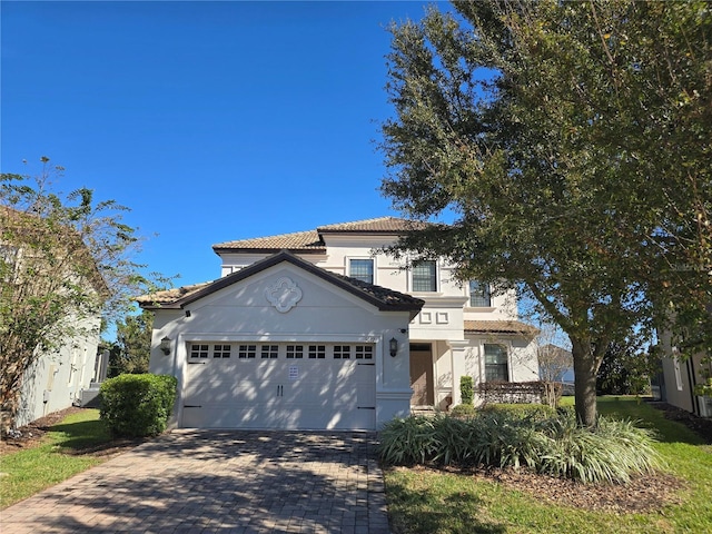 9037 Shadow Mountain St, Davenport, FL 33896 - mediterranean / spanish-style home with decorative driveway, a tile roof, a garage, and stucco siding