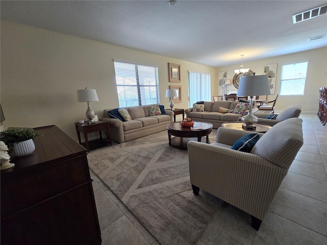 living room featuring tile patterned floors, an inviting chandelier, and a wealth of natural light