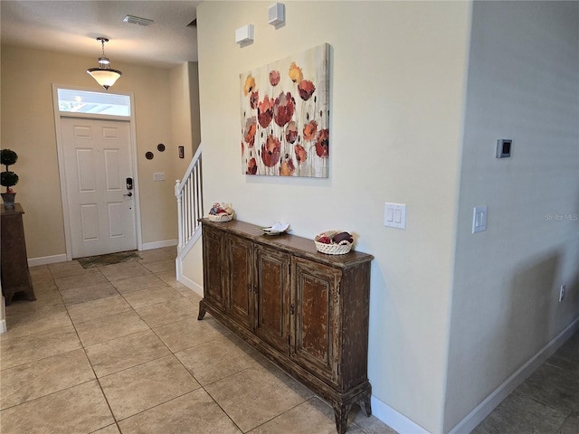 tiled foyer with a textured ceiling