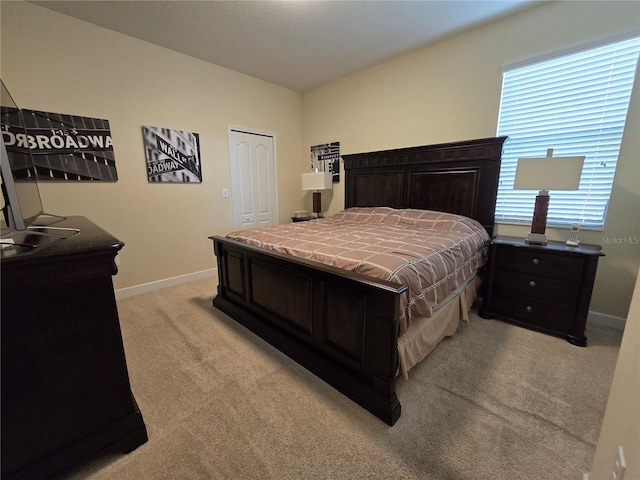 bedroom featuring light colored carpet and a closet