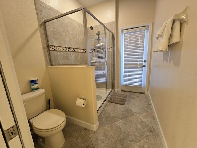 bathroom with tile patterned floors, a shower with door, and toilet