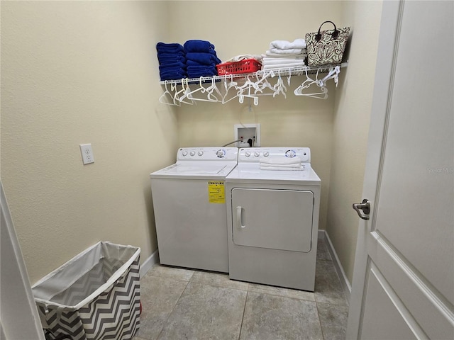 washroom with washing machine and clothes dryer and light tile patterned floors