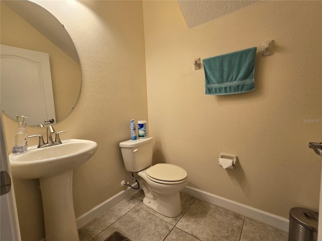 bathroom with tile patterned flooring, toilet, and sink