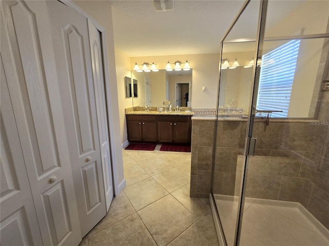 bathroom with tile patterned flooring, vanity, and a shower with shower door