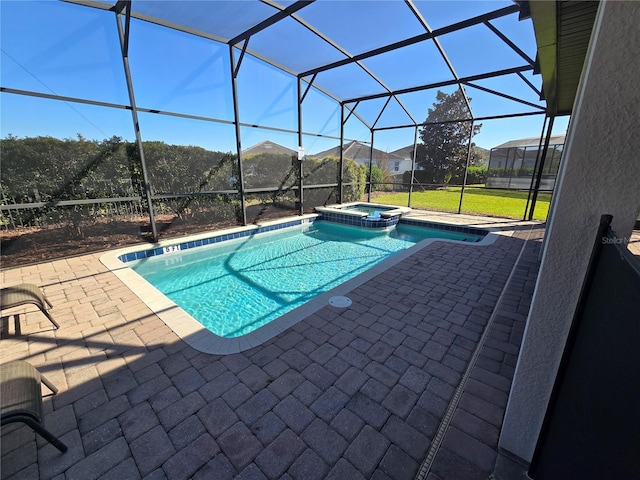 view of swimming pool featuring glass enclosure, a patio area, and an in ground hot tub