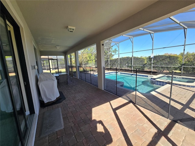 view of swimming pool featuring a lanai, an in ground hot tub, and a patio