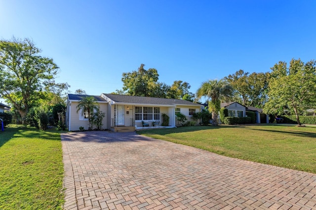 single story home featuring covered porch and a front lawn