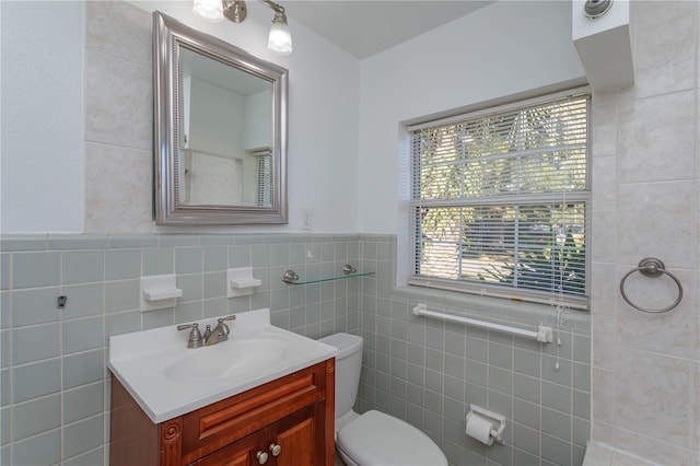 bathroom featuring vanity, toilet, and tile walls