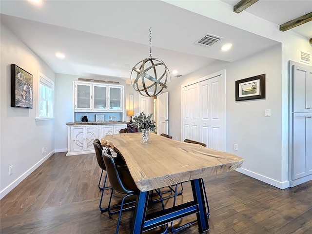 dining area featuring beamed ceiling, dark wood-type flooring, and an inviting chandelier