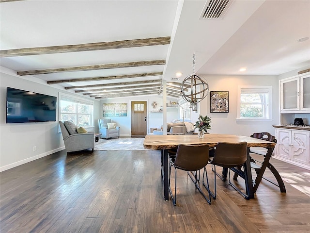 dining area with lofted ceiling with beams, a healthy amount of sunlight, dark hardwood / wood-style floors, and an inviting chandelier