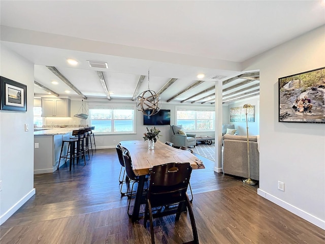 dining room with beam ceiling, dark hardwood / wood-style flooring, and a wealth of natural light