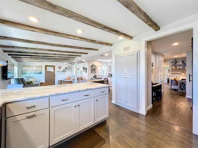 kitchen featuring dark hardwood / wood-style flooring, light stone countertops, beamed ceiling, and white cabinets