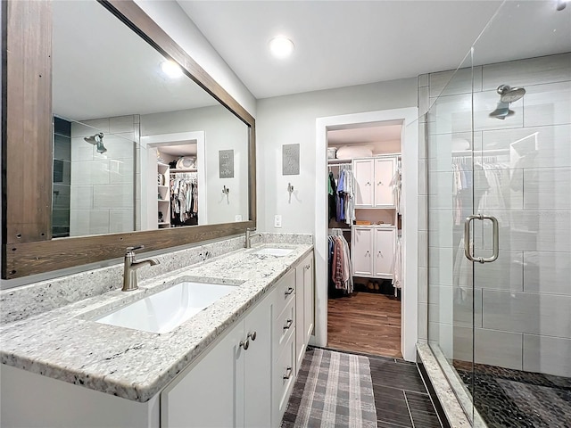 bathroom featuring hardwood / wood-style floors, vanity, and a shower with door