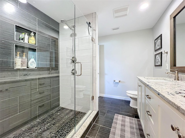 bathroom featuring vanity, toilet, and an enclosed shower