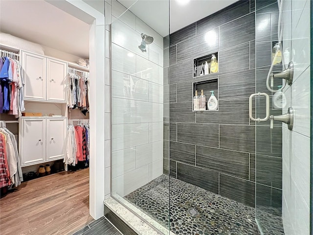 bathroom featuring wood-type flooring and an enclosed shower