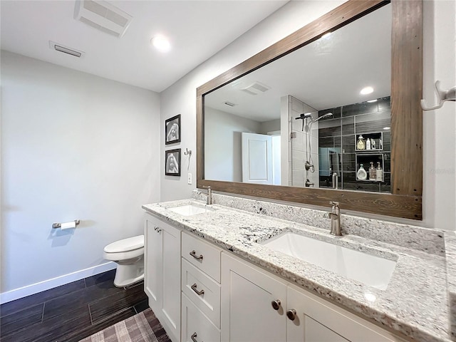 bathroom with vanity, toilet, and a shower with door