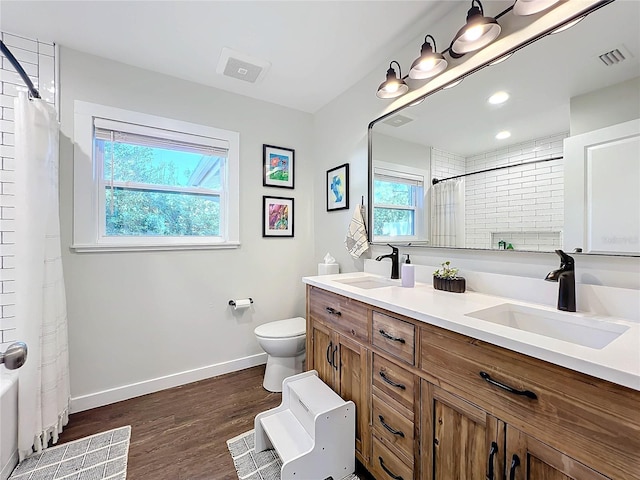 bathroom featuring hardwood / wood-style flooring, vanity, curtained shower, and toilet