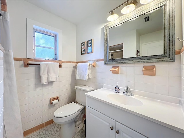 bathroom with tile patterned flooring, vanity, tile walls, and toilet