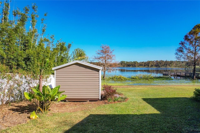 view of yard featuring a water view and a shed