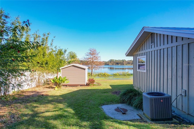 view of yard featuring a storage unit, a water view, and cooling unit