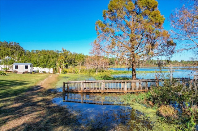 dock area with a water view and a yard