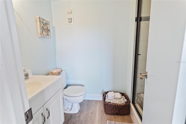 bathroom with vanity, hardwood / wood-style flooring, toilet, and an enclosed shower