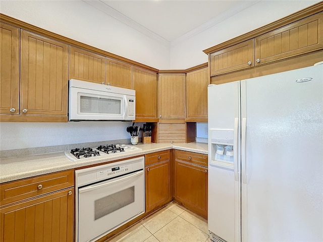 kitchen with light tile patterned floors, white appliances, and crown molding