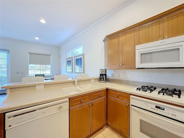 kitchen featuring plenty of natural light, crown molding, white appliances, and sink