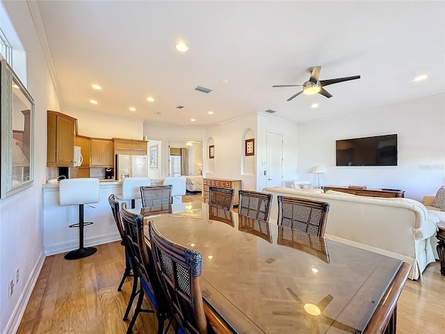 dining area featuring ceiling fan, crown molding, and light hardwood / wood-style flooring