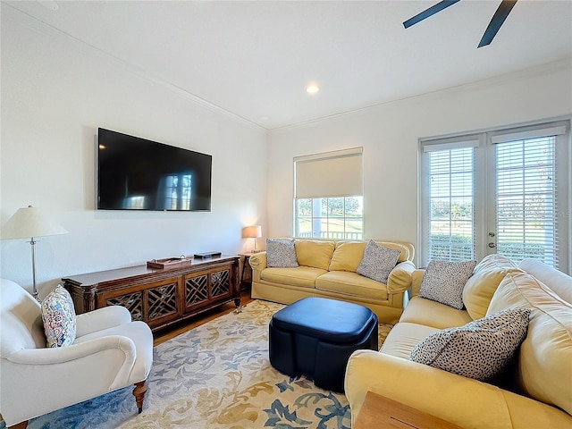 living room featuring hardwood / wood-style floors, ceiling fan, ornamental molding, and french doors