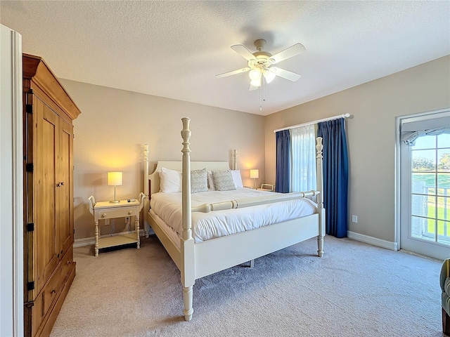 carpeted bedroom with ceiling fan and a textured ceiling