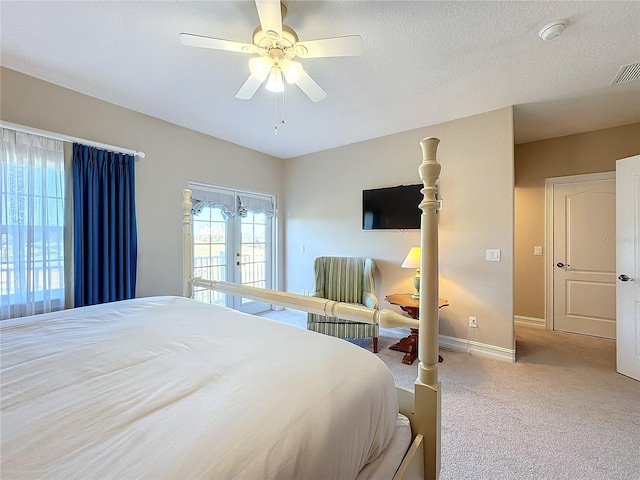 carpeted bedroom featuring french doors, a textured ceiling, and ceiling fan