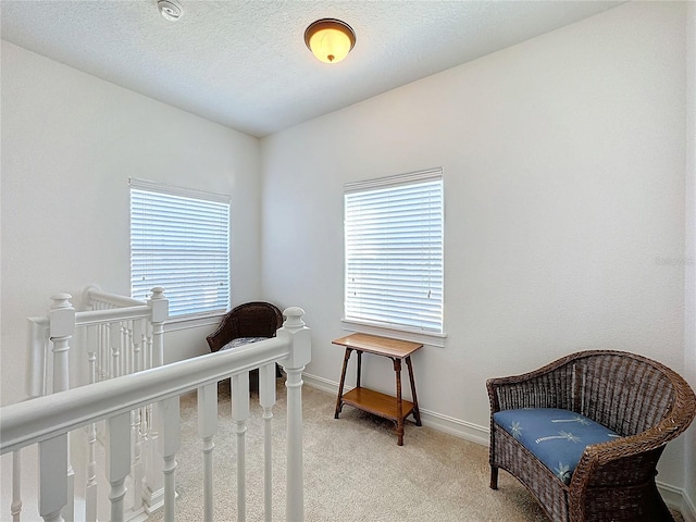 bedroom with multiple windows, light colored carpet, and a textured ceiling