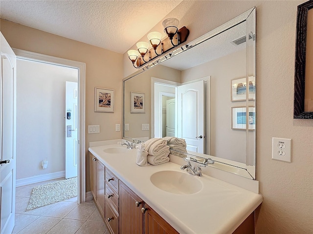 bathroom featuring tile patterned flooring, vanity, and a textured ceiling