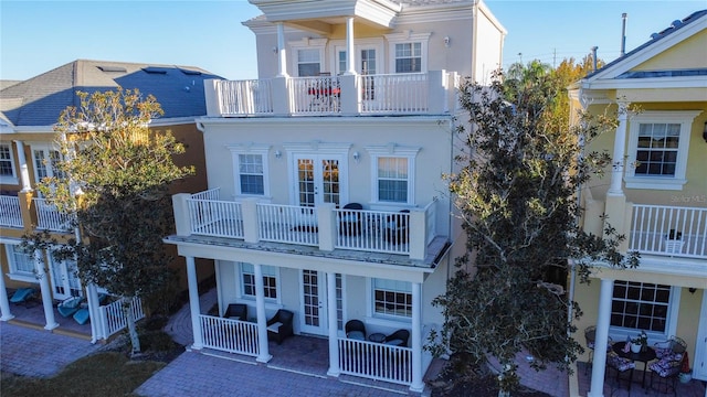 back of property featuring a balcony and french doors