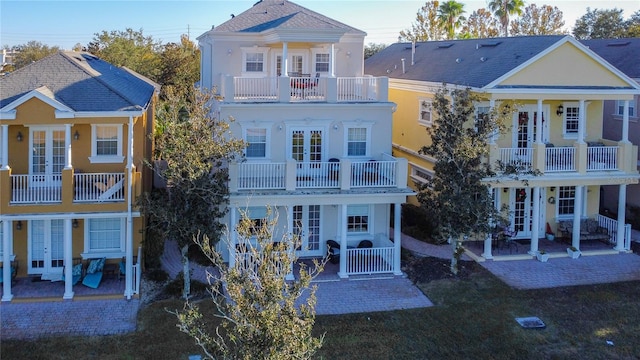 back of house featuring a balcony and french doors