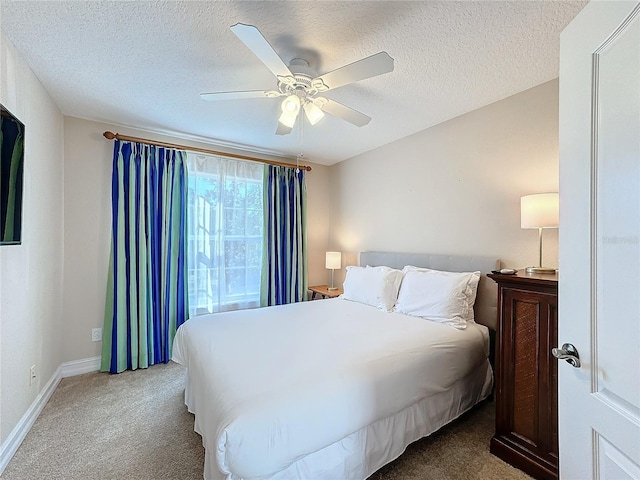 carpeted bedroom with ceiling fan and a textured ceiling