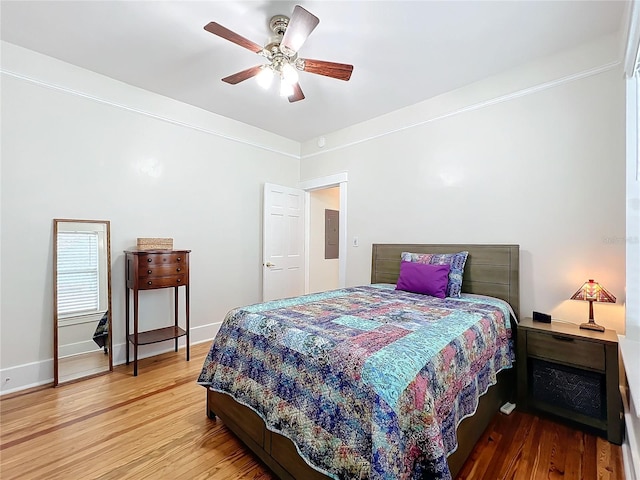 bedroom featuring hardwood / wood-style floors, ceiling fan, and electric panel