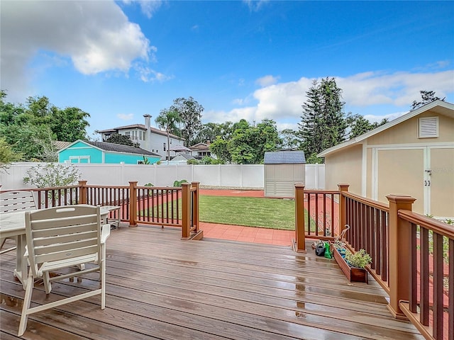 wooden deck featuring a yard and a storage shed