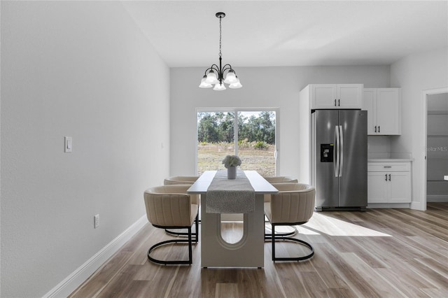 dining space with a chandelier and light hardwood / wood-style flooring