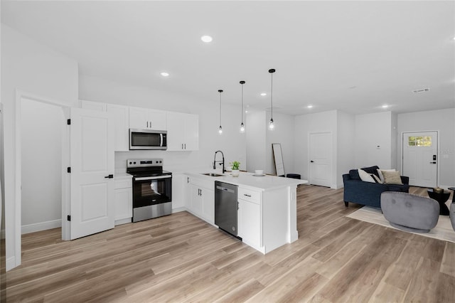 kitchen featuring sink, light wood-type flooring, decorative light fixtures, kitchen peninsula, and stainless steel appliances